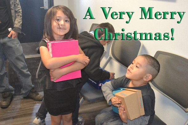 Six-year-old Aleah and five-year-old Tyler embrace their new shoes at Thursday's annual Lemoore Police Department Shoe Drive.